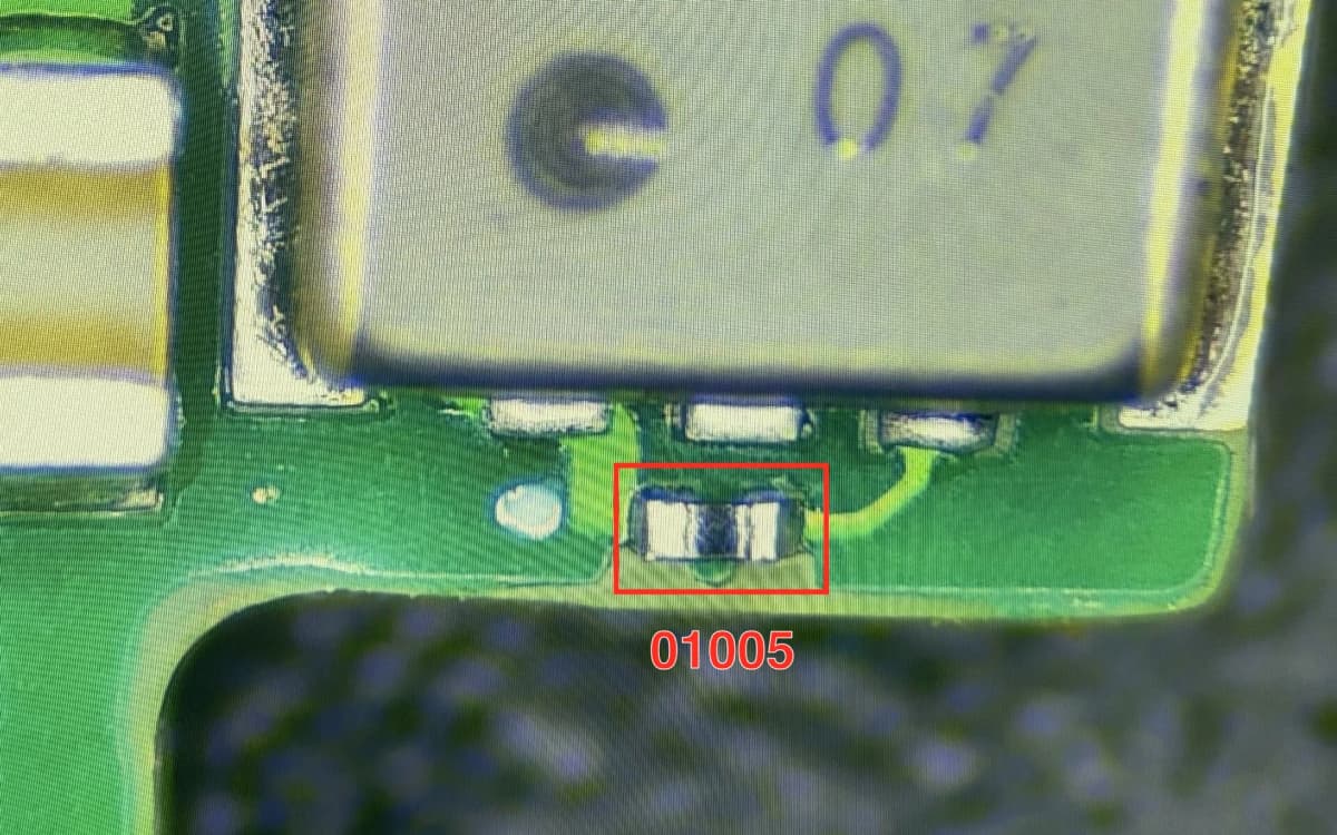 Composant 01005 placé et brasé sur une carte PCB de production, vu au microscope